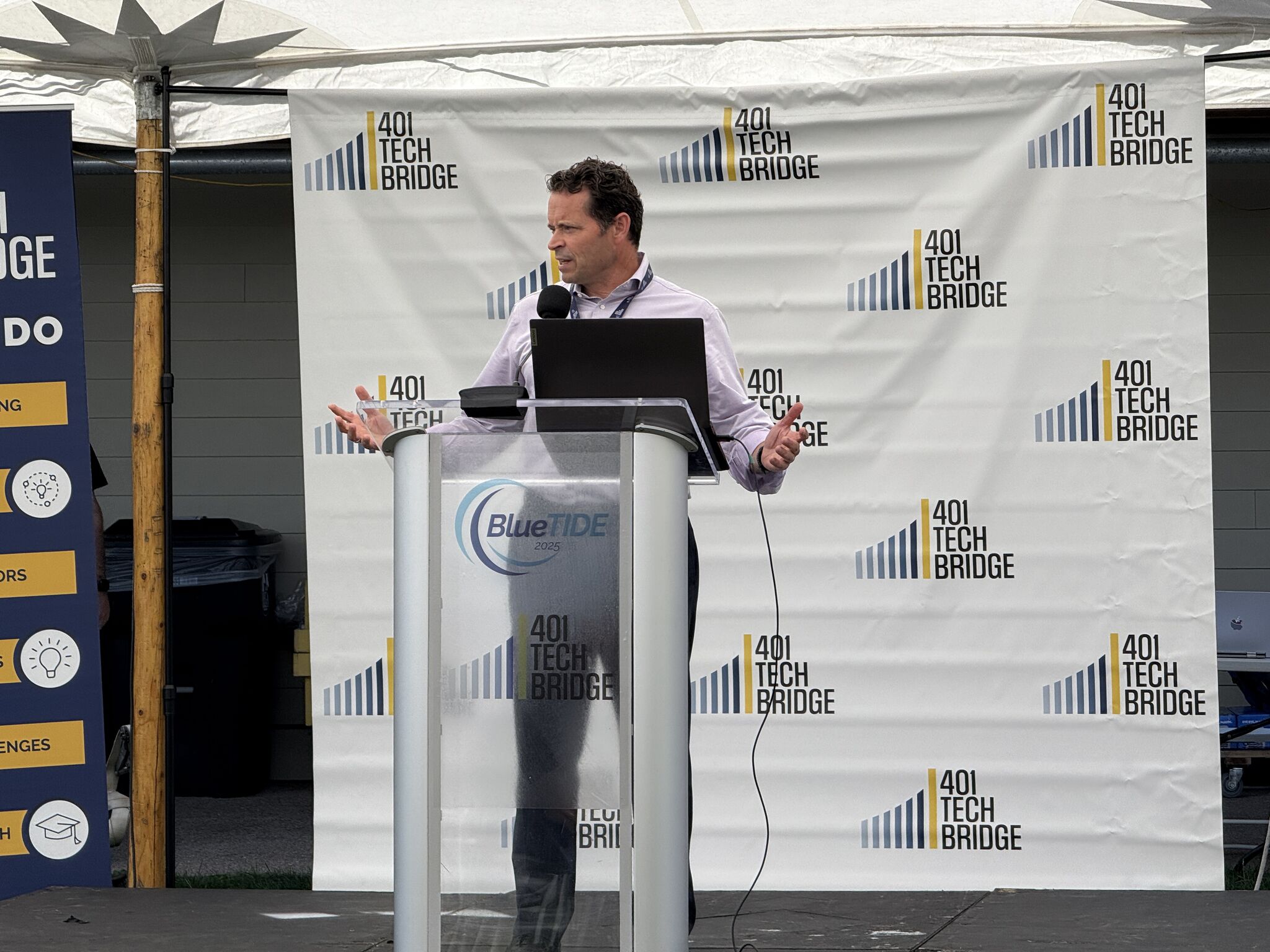 LeVanta Tech CEO Kelly A. Echols speaking at a podium during the BlueTIDE 2025 event, with 401 Tech Bridge branding in the background.