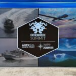 FATHOMWERX Summit signage featuring maritime, air, and unmanned systems imagery at the conference venue.