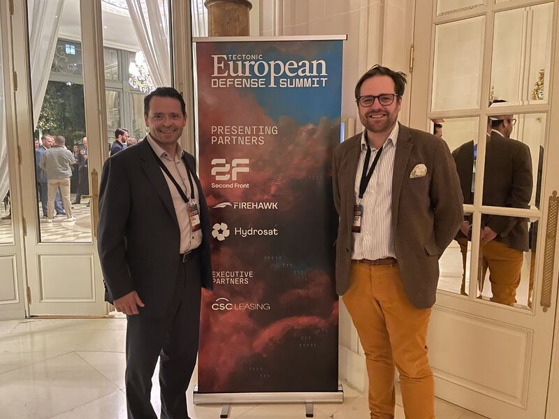 LeVanta Tech representatives standing beside a Tectonic European Defense Summit banner at the conference venue in Paris.